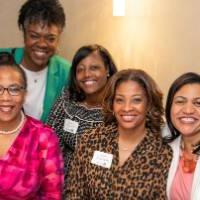 5 women at a table smiling